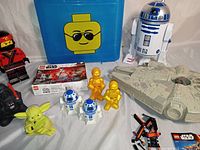 Wide view of the entire toy lot showing large R2-D2, Lego storage box, Millennium Falcon micro machines, Lego figures, and boxed Lego Star Wars set with 109 pieces