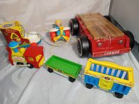 Photo showing all four toys including lacing shoe, pull airplane, circus train, and block wagon with wooden blocks.