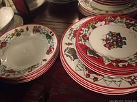 Close-up of stack of plates showing detailed Christmas Town village design and red border pattern.