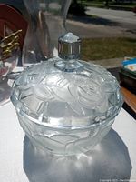 Photo of the clear crystal covered bowl showing floral embossed rose design throughout with knob handle on cover