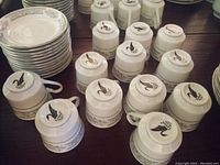 Photo showing a large number of bowls, saucers, teacups stacked, displaying the pattern and quantity.