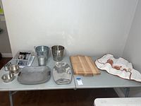 Full view of all barware items on the table including buckets, trays, bowls, cutting board, and utensil pouch