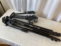 Tripod folded and laying on table showing length and overall condition