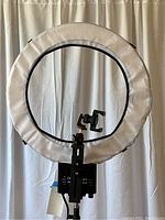 Front view of the 19 inch diameter Diva SuperNova video ring light with white diffusion cover and camera/device mounting bracket, attached to a tripod stand.