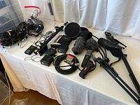 Full view of lot on table showing microphones, cables, stands, pop filters, and wireless units