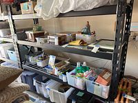 Storage rack with four shelves loaded with various household items to show storage capacity.