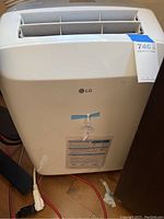 Front view of white LG portable air conditioner unit with LG logo and instruction label