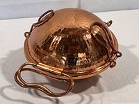 Copper roasting pan closed, showing hammered copper finish and side handles