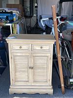 Front view of small storage cabinet and the wooden rail shelf standing adjacent