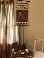 Fabric wall hanging banner for Chowning's Tavern with vintage art print hung on curtain rod
