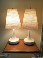 Two identical lamps on small table, both lit, showing overall appearance