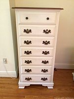 Front view of tall chest showing seven drawers and hardware