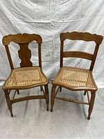 Front view of two antique wooden chairs with cane seats, showing different backrest designs and condition.