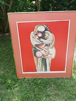 Full framed print showing abstract figures embracing with salmon pink mat and some discoloration on mat.