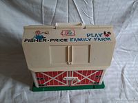 Front view of Fisher Price Play Family Farm barn with visible graphics and handle
