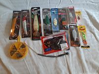 Wide view of unopened packaged fishing lures including varied brands and types, colorful packaging with some soft plastics visible