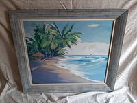 Framed full view of the tropical beach scene painting with palm trees, hut, ocean, and sky.