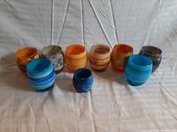 Front view showing all 9 vintage drinking glasses with planet-themed designs and varying colors including blue, orange, gold, brown, gray, and dark shades