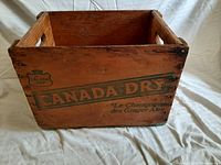 Front view of wooden crate showing Canada Dry branding and French text on front panel.