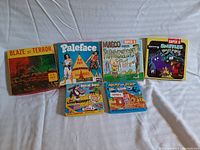 Six Super 8 mm film boxes arranged in two rows showing full front box artwork, including titles: Blaze of Terror, Paletace (two versions), Mr. Magoo, Heckle and Jeckle, Little Roquefort & The Pasture Panic.