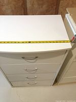 Top view showing white particle board surface with a measuring tape across 24 inches width.