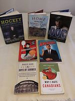 Front covers of the 7 books in the lot, arranged standing and lying flat showing titles and cover art.
