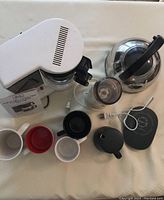 Top view of all items in the lot including coffee maker, kettle, grinder, mugs, and mug warmer