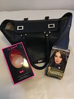 Photo showing black Heys handbag, La Senza Feather-Lite push-up bra in unopened pink and black packaging, and L'Oreal Préférence hair colour box.
