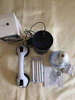 Photo showing white wall grabber with suction cups, blue Smart Devil humidifier with box, humidifier filters, and instruction booklet for HoMedics humidifier.