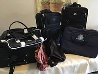 Photo showing all bags together: 3 black suitcases, Adidas gym bag, 2 toiletry bags