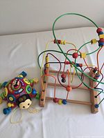 Wooden bead drop dexterity toy with multiple colorful wires and beads attached to wooden base