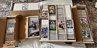 Collection of football cards arranged in boxes and stacks on a countertop, showing many rows of cards with some cards facing forward.