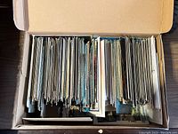 Cardboard box filled with vertically stored postcards, visible from above.