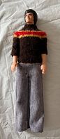 Front view of the Donny Osmond doll wearing a brown sweater with red and yellow stripes and grey pants.