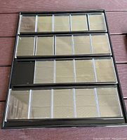 Front view of black framed sports card holder showing 20 clear vertical slots for cards.