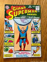 Front cover of Giant Superman Annual #8 with Superman holding earth and inset images of characters and story titles.