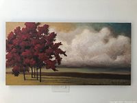 Front view of the landscape painting showing red trees and cloudy sky on canvas.