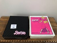 Black carrying case with small dot pattern and pink Barbie text logo.