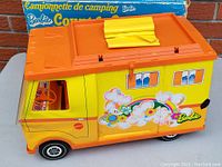 Vintage Barbie Country Camper toy van with yellow body, orange roof, colorful cloud and flower graphics, and Barbie logo on the side.