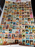 Photo showing top left and center area of large uncut 1974-75 OPC hockey card sheet with multiple players and team leaders.