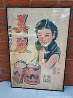 Full view of the framed Asian cigarette advertisement poster showing woman and two cigarette packages.