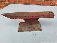 Side angle view of the anvil showing pointed horn and flat rectangular top surface