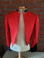 Front view of red military dress jacket on mannequin showing open front and detailing