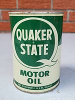 Front view of vintage Quaker State motor oil can showing logo and product details.