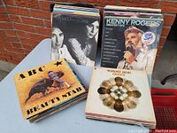 Image showing stacks of vinyl LP records including Kenny Rogers Greatest Hits, ABC Beauty Stab, Tommy Roe Dizzy, and others.
