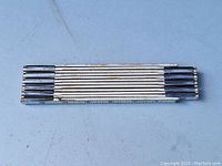 Top view of the folded vintage folding ruler measure showing compact folded position with visible measuring markings.
