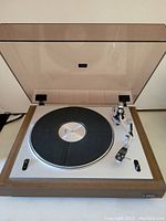 Front view, dust cover open, platter and tonearm visible