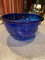 Side view of the large cobalt blue glass bowl showing shape, color, and rim thickness.