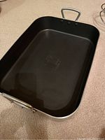 Top view of the rectangular roasting pan showing black non-stick interior and two metal handles.
