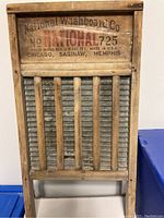Photo of vintage wooden washboard by National Washboard Co with metal and wooden rods scrubbing surface and label with company and model info